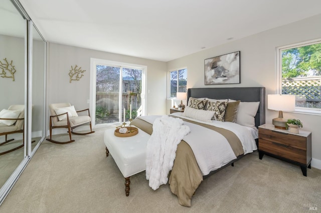 bedroom with light carpet, multiple windows, and baseboards