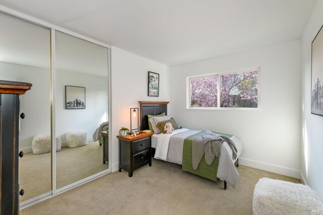 bedroom with light carpet and baseboards