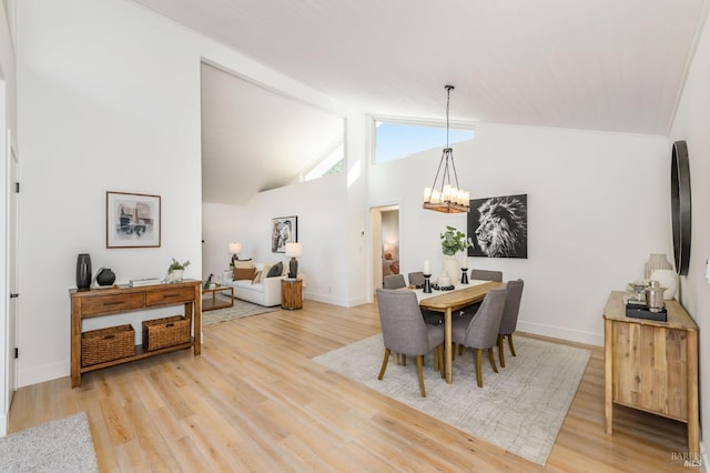 dining room featuring a chandelier, baseboards, and light wood-style floors