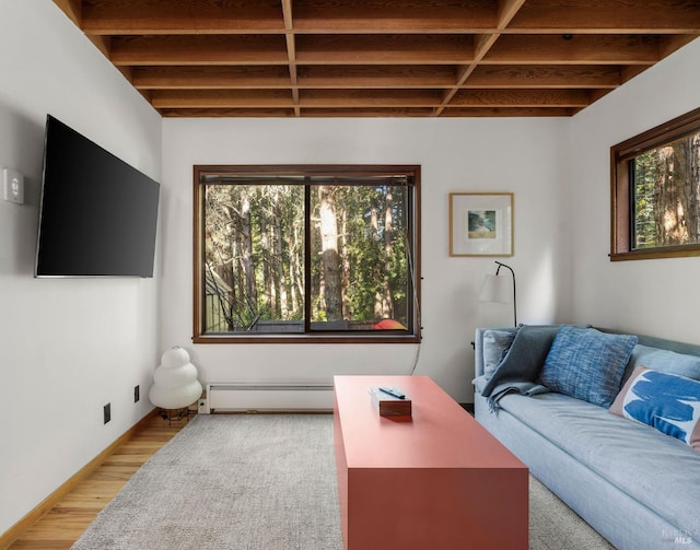 living room featuring a baseboard heating unit, beamed ceiling, wood finished floors, and baseboards