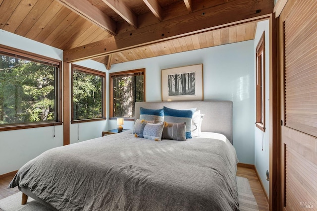 bedroom with wooden ceiling, vaulted ceiling with beams, baseboards, and wood finished floors