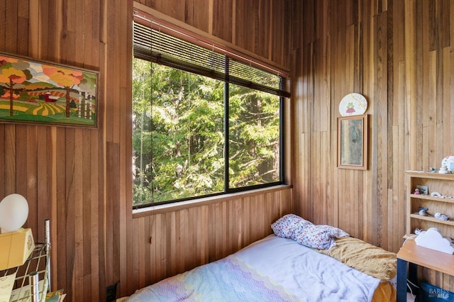 bedroom featuring wood walls