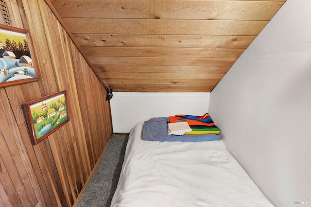 carpeted bedroom with lofted ceiling, wood ceiling, and wooden walls