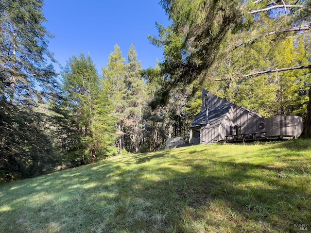 view of yard featuring a forest view and an outdoor structure