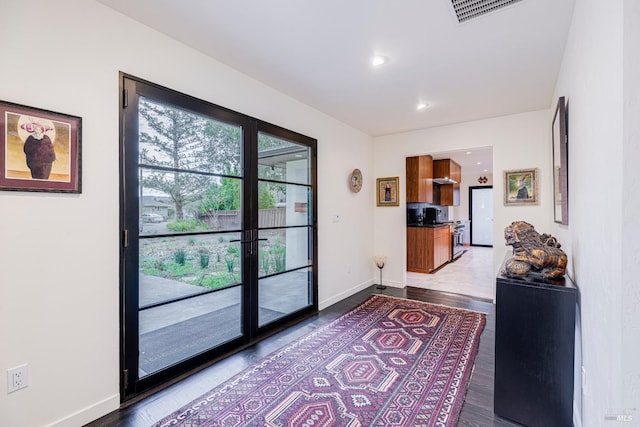 doorway featuring recessed lighting, dark wood-style flooring, visible vents, and baseboards