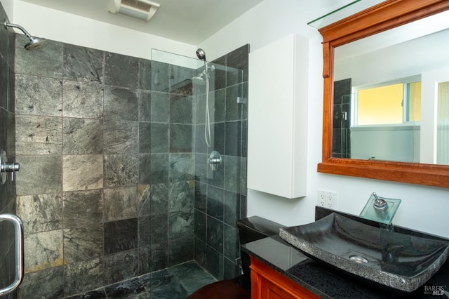 bathroom with vanity, a tile shower, and visible vents