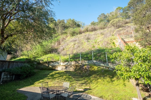 view of yard featuring a patio area, a fenced backyard, and outdoor dining space