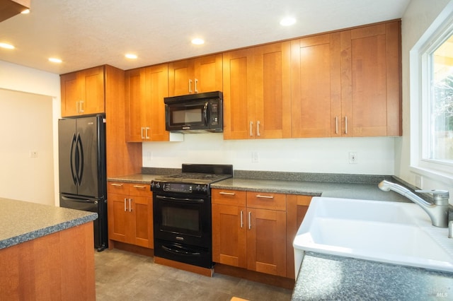 kitchen with black appliances, brown cabinetry, a sink, and recessed lighting