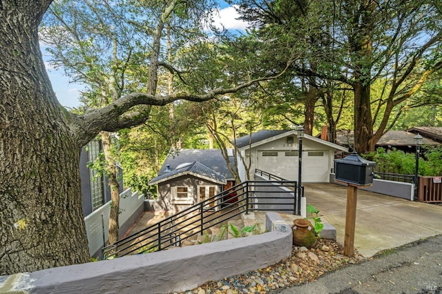 view of front facade with a garage, fence, and an outdoor structure