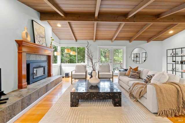 living room with french doors, a fireplace, lofted ceiling with beams, wood ceiling, and wood finished floors