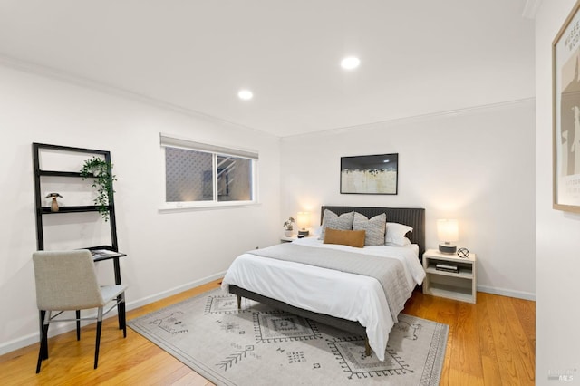 bedroom featuring light wood-type flooring, crown molding, baseboards, and recessed lighting