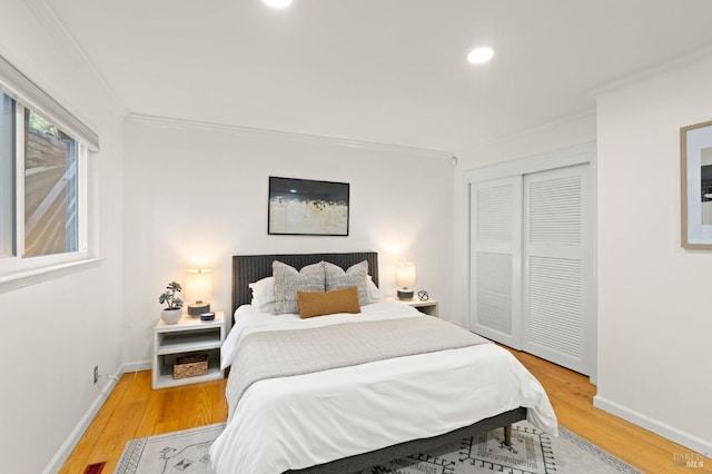 bedroom with recessed lighting, baseboards, ornamental molding, a closet, and light wood finished floors