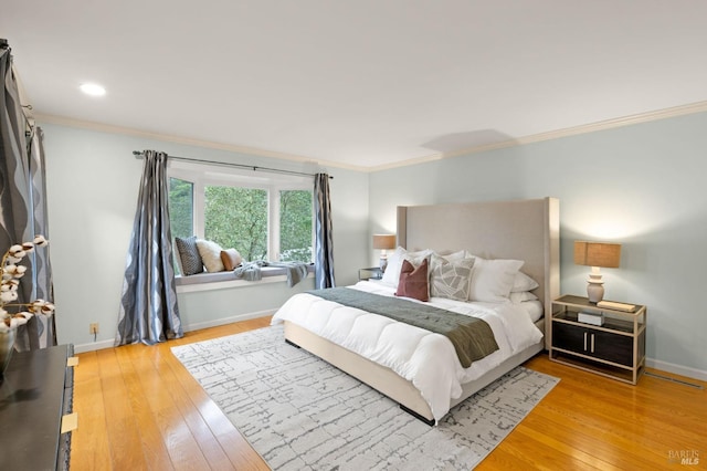 bedroom with recessed lighting, crown molding, light wood-style flooring, and baseboards