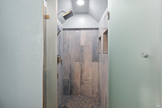 bathroom featuring a stall shower, visible vents, and lofted ceiling