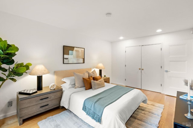 bedroom featuring light wood-style floors, a closet, and recessed lighting