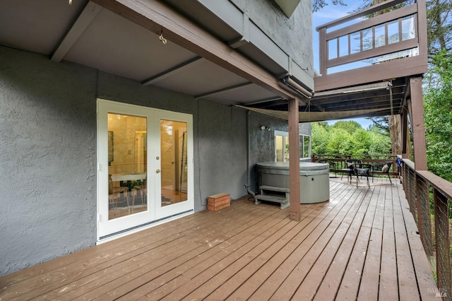 deck with french doors and a hot tub