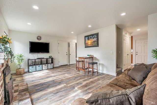 living area with recessed lighting, baseboards, and wood finished floors