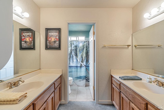 full bathroom featuring two vanities, a sink, and toilet