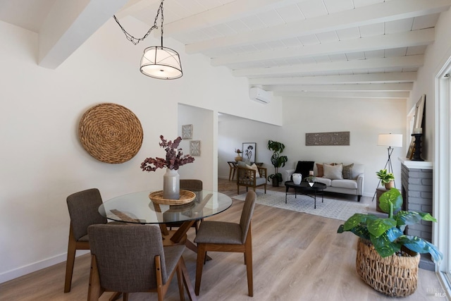 dining area with vaulted ceiling with beams, light wood-style flooring, and baseboards