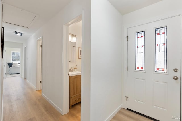 foyer featuring light wood-style flooring and baseboards