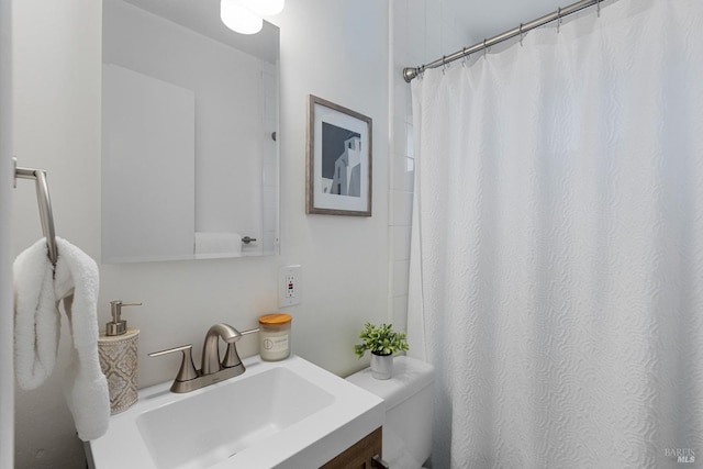 bathroom with toilet, curtained shower, and vanity