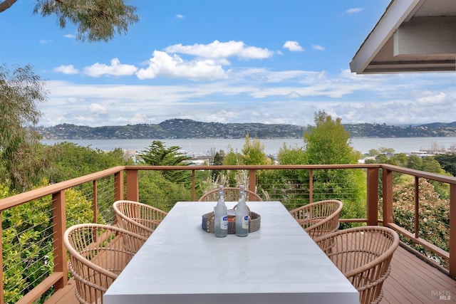 balcony with outdoor dining area and a deck with water view