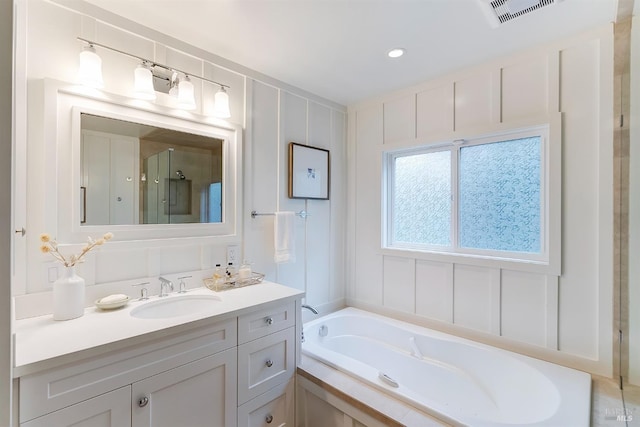 full bath with a stall shower, visible vents, a garden tub, and vanity