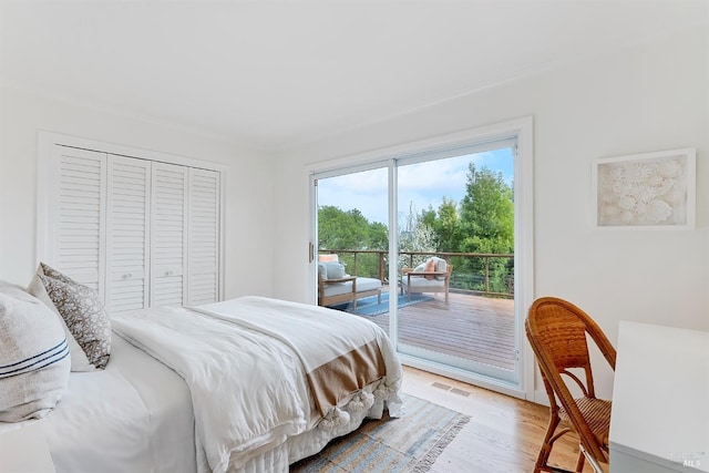 bedroom featuring access to exterior, a closet, visible vents, and light wood-style floors