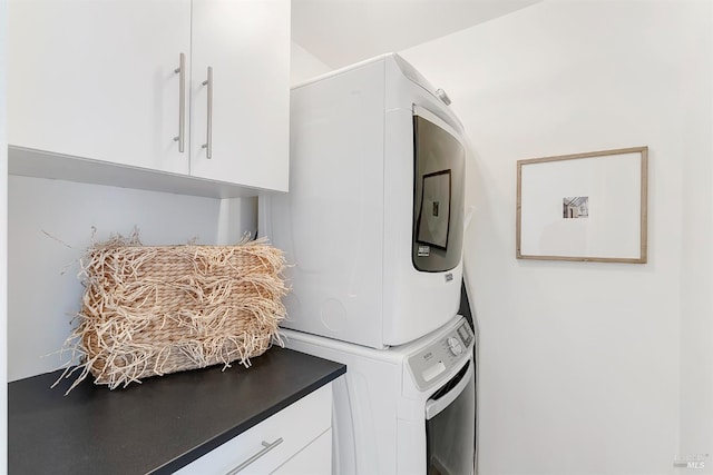 laundry area with stacked washing maching and dryer and cabinet space