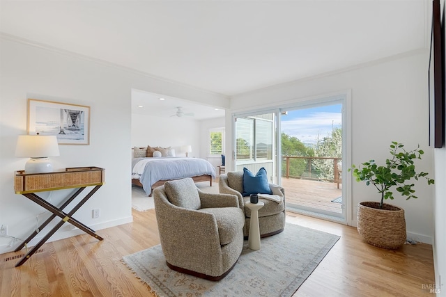 bedroom featuring crown molding, light wood-type flooring, baseboards, and access to exterior