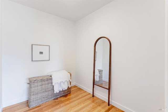 sitting room with baseboards and light wood-style floors