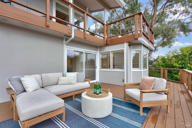 wooden terrace with an outdoor living space