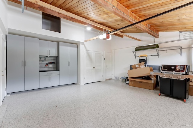 garage featuring wooden ceiling and a garage door opener