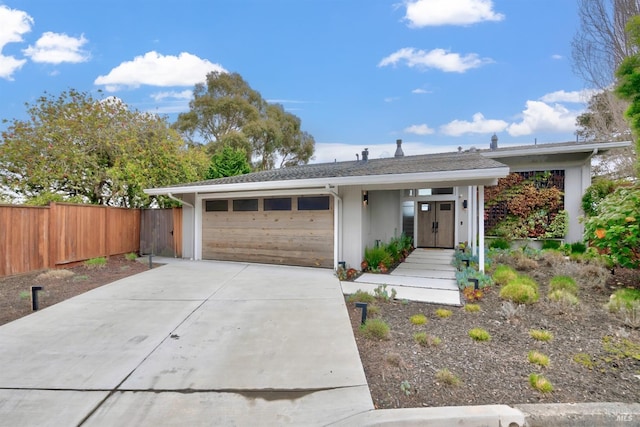 view of front of home with a garage, fence, and driveway