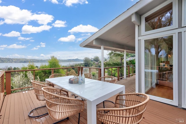 wooden deck featuring outdoor dining area and a water and mountain view