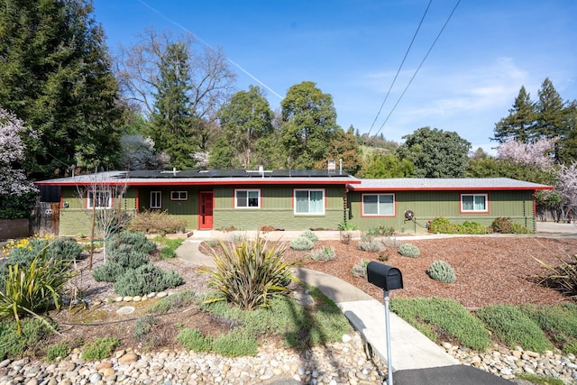 ranch-style house with roof mounted solar panels