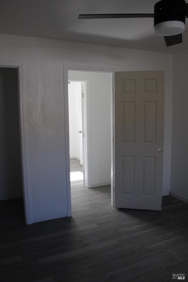 corridor with baseboards and wood finished floors