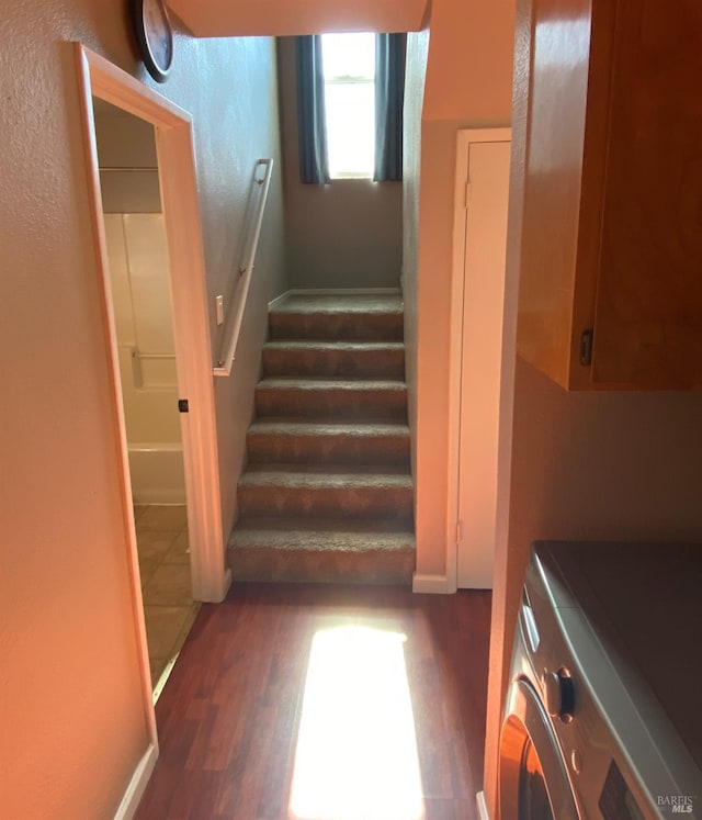 stairs featuring washer / dryer and wood finished floors