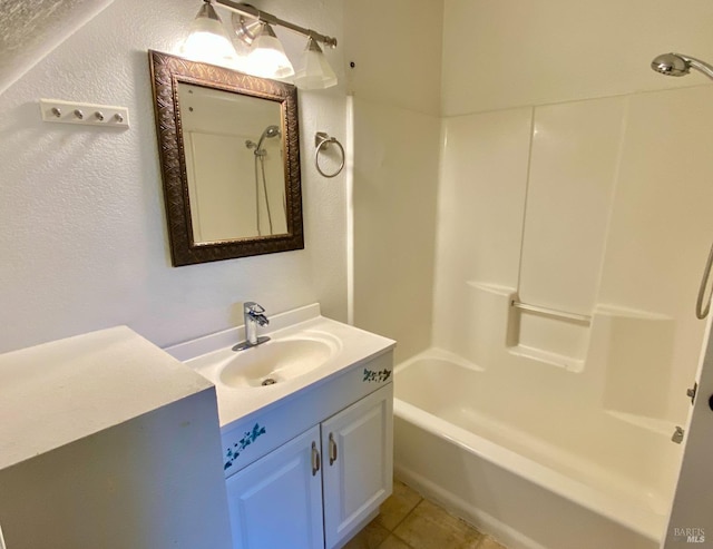 full bath featuring tile patterned flooring, shower / bath combination, a textured wall, and vanity