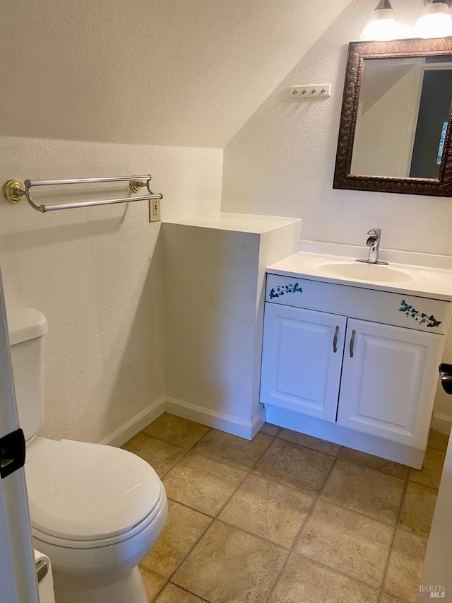 bathroom with baseboards, a textured wall, vanity, and toilet