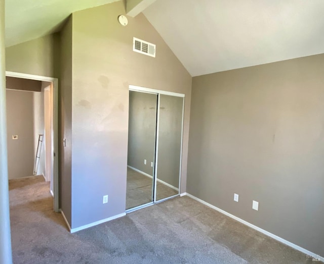 unfurnished bedroom featuring high vaulted ceiling, a closet, visible vents, and carpet flooring