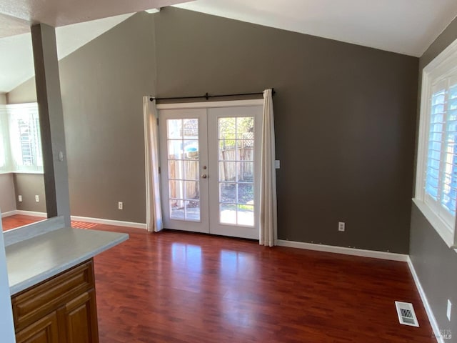 doorway to outside with lofted ceiling, dark wood-type flooring, visible vents, baseboards, and french doors