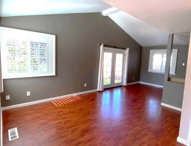 unfurnished room with vaulted ceiling with beams, wood finished floors, visible vents, baseboards, and french doors