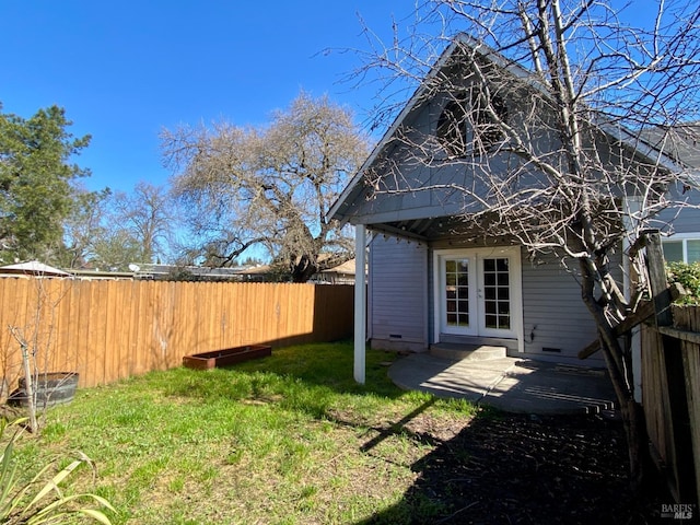 view of yard featuring french doors and a fenced backyard