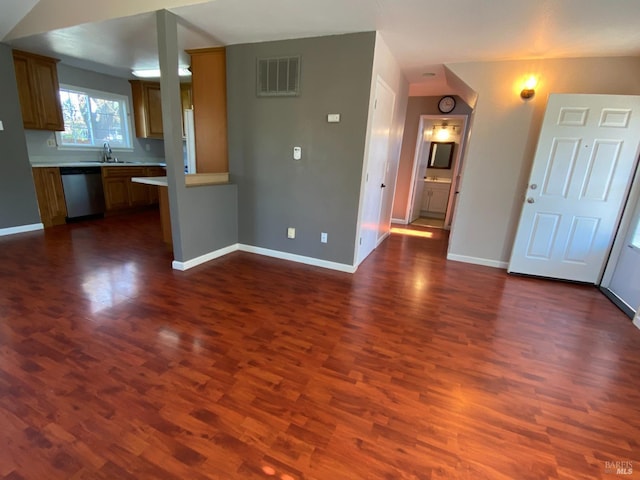 unfurnished living room featuring dark wood-style floors, baseboards, visible vents, and a sink