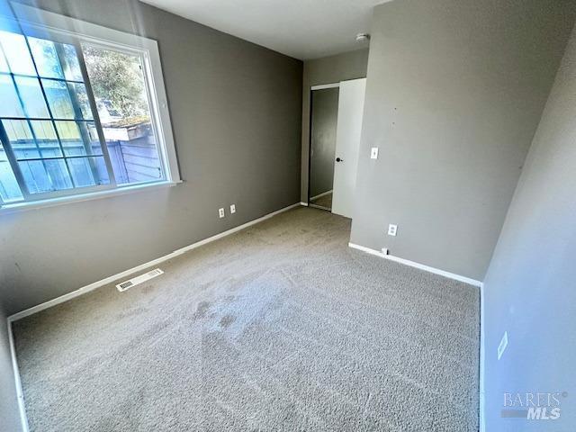 unfurnished bedroom with baseboards, visible vents, and carpet flooring