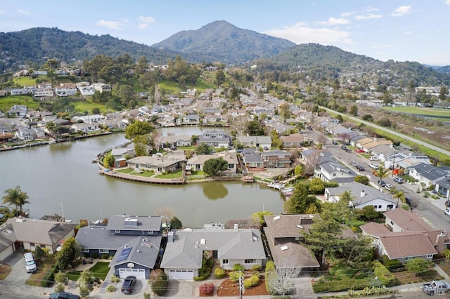 drone / aerial view featuring a water and mountain view and a residential view