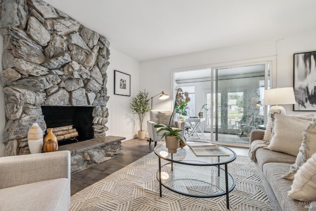 living area featuring a stone fireplace and wood finished floors