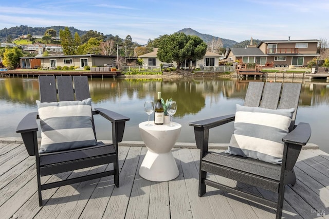 view of dock with a residential view and a water and mountain view