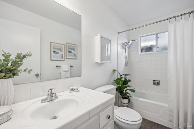 bathroom featuring toilet, shower / bath combination with curtain, and vanity